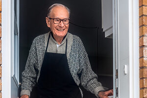 Elderly man opening door