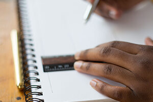 Hands holding a ruler and pen