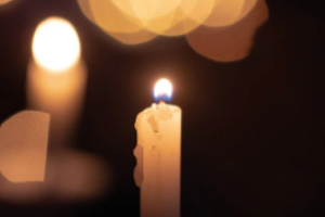 Lit candle in the dark