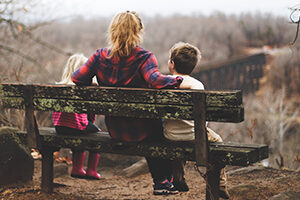 Woman and two children sitting on a bench