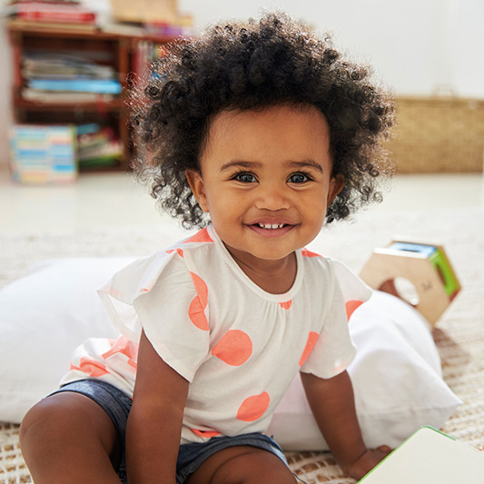 Happy Baby Girl Playing With Toys In Playroom