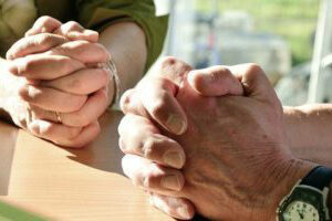Man's and woman's hands in prayer