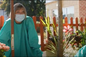 Debbie Thrower visiting a care home in a face mask and gown