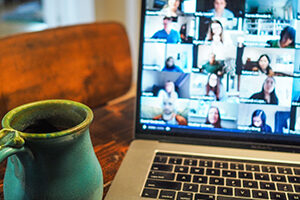Mug and laptop showing a video conference call