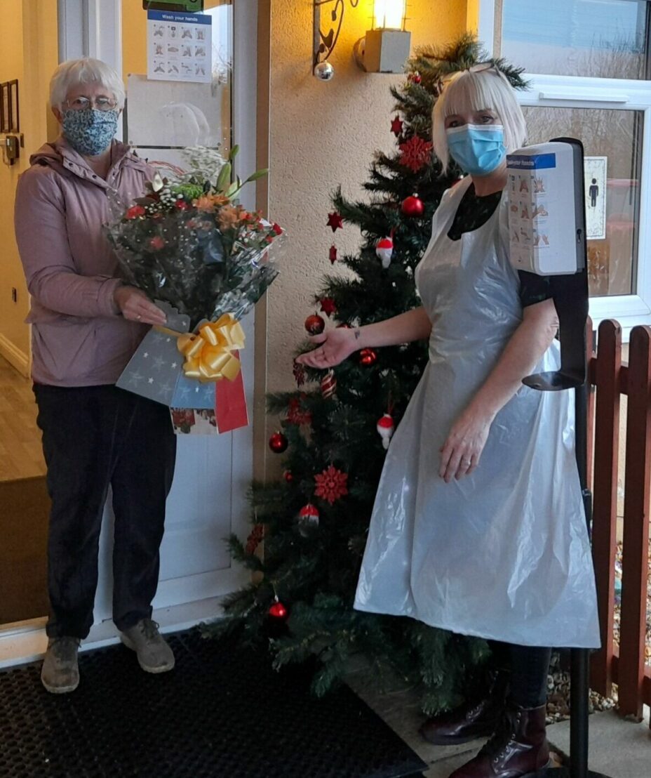 Anna Chaplain presents flowers to a care home worker