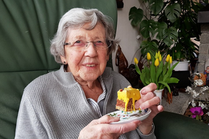 Old lady with tulips eating cake and smiling