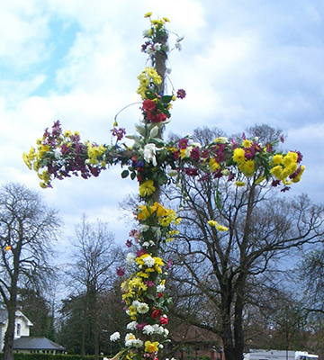 Cross covered with flowers of different colours