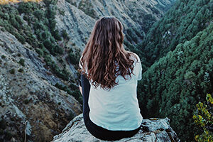 Woman sitting on a mountaintop