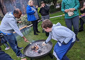 People toasting marshmallows over a coal fire