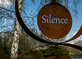 A rusty sign with the word 'silence'