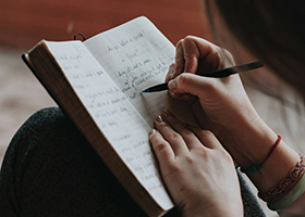 Young woman writing in a note book